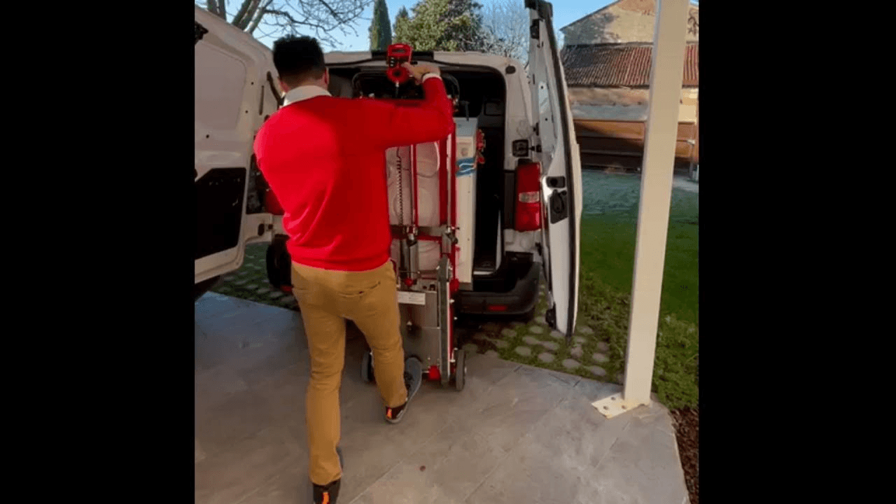 A man loads a washing machine into the van using the electric load lifting mechanism of the stair trolley Buddy Lift